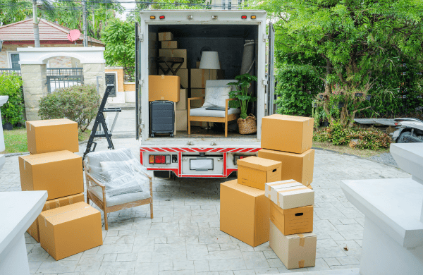 Camion de déménagement chargé de cartons et meubles dans un quartier résidentiel